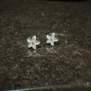 Silver tone Plumeria stud earrings with faux diamond in center